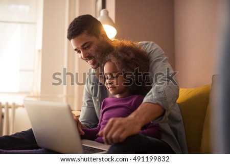 African american dad and his daughter using a computer.