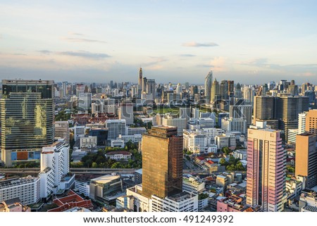 Bangkok city in the evening. and warm sunlight effect create highlight shadow, reflection in the sky, building. (With blur trademark, brand, logo)