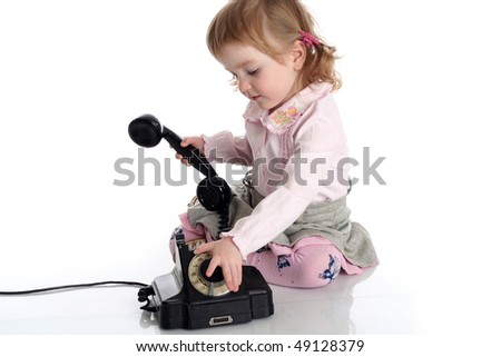 Little girl with old black phone. Studio shot on white background