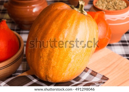 Big and small pumpkin and wooden utensils in rustic style