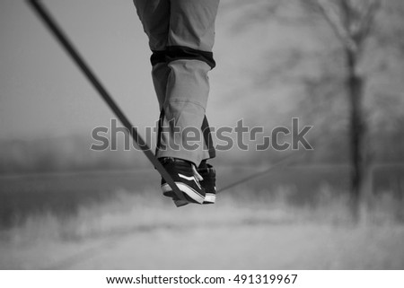 Slacklining in the  park. black and white photo