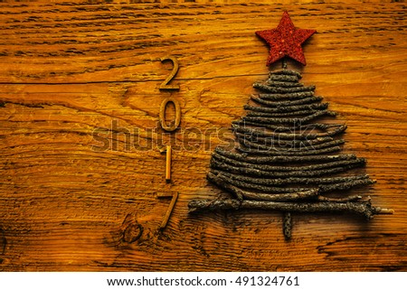 Sign symbol from many dry Stick Christmas Tree. a lot trunk lie on vintage style wooden texture background. Empty copy space for inscription. Idea of merry new year 2017 holiday. red star above. 