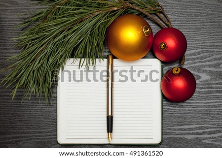 Fountain pen on a notebook on a wooden table and Christmas decorations