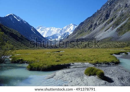 Scenic landscape with river in the valley on the background of mountains, Russia