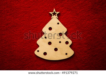 wooden Christmas tree toy decoration on red material background