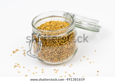 Closeup of bee pollen.Bee pollen granules in glass jar/container. bee pollen boosts the immune system.Food ingredient for health,healthy leaving,medical,health-care concept. Isolated,white background.