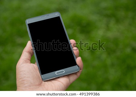 Smartphone in hand with green background