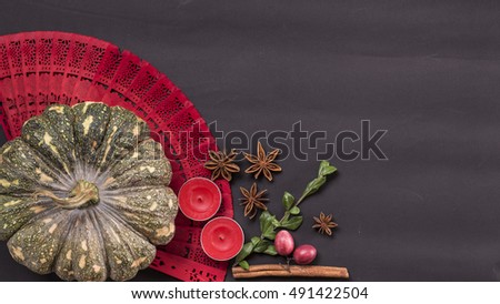 Halloween pumpkin, spices and candles dark background flat lay