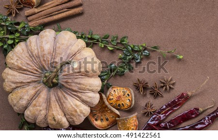 Halloween pumpkin, spices and chili peppers wooden background flat lay
