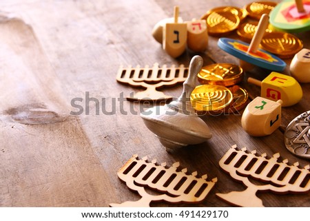 Image of jewish holiday Hanukkah with wooden dreidels colection (spinning top) and chocolate coins on the table

