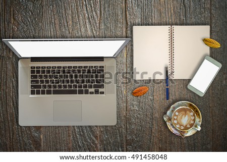 Wood desk with office supplies and a cup of coffee, top view