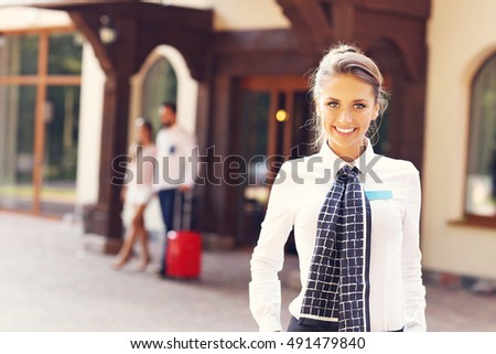 Picture showing manager standing in front of hotel