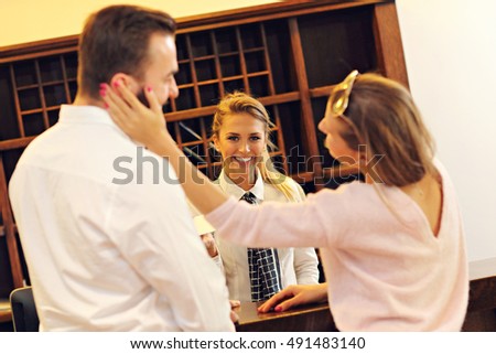 Picture of couple and receptionist at counter in hotel