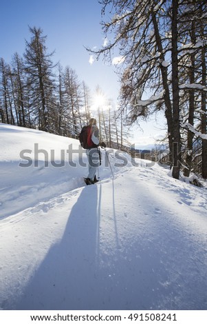 woman hiking in the mountains with snowshoes