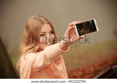 Photography people concept. Blonde young girl taking a selfie. Beautiful woman takes picture with mobile phone.