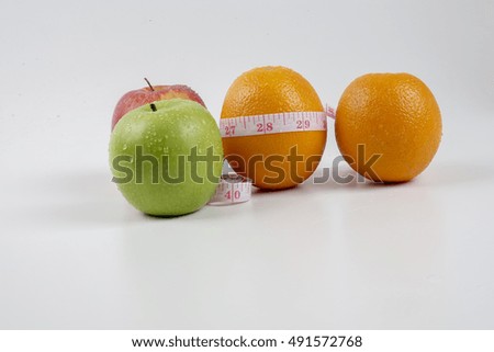 Green apple, red apple ,yellow orange and measuring tape. Diet concept