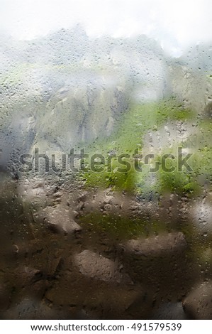 Raining view through window at the mountains