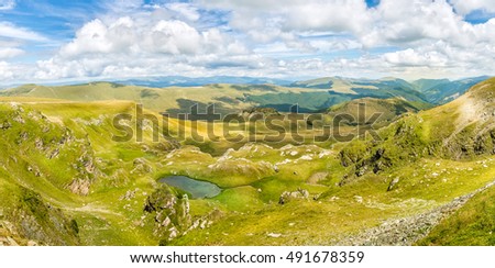 Landscape panorama with a blue sky and white clouds above the Carpathian mountains in Romania Royalty-Free Stock Photo #491678359