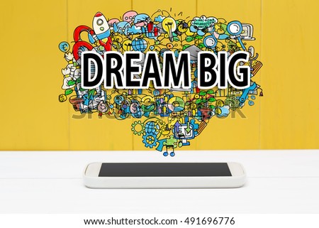 Dream Big concept with smartphone on yellow wooden background