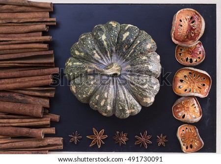 Halloween pumpkin cinnamon sticks and aniseed on chalkboard flat lay