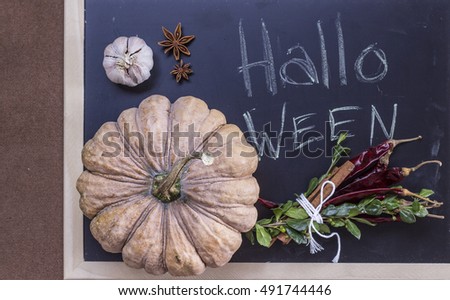Letters Halloween on chalkboard and pumpkin, chili peppers, garlic, aniseed flat lay