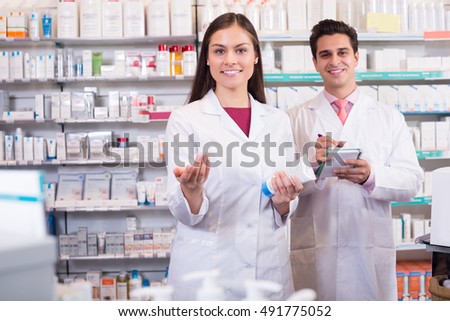 Positive pharmacist and pharmacy technician working in drugstore