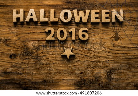 HALLOWEEN 2016 written with wooden letters and numbers or digital  over a rustic wood retro vintage plank background. inverted star - pentagram. Spider web