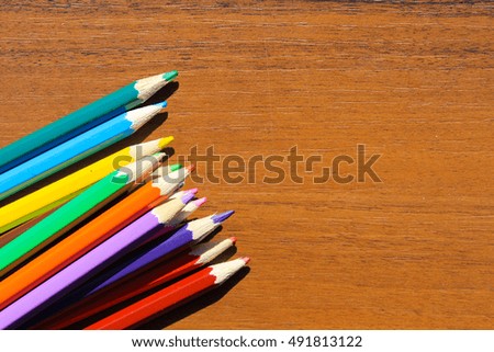 Colourful pencils on the wooden background