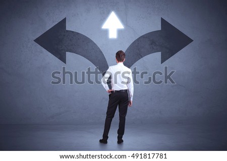 Businessman taking a decision while looking at arrows on the wall concept background
