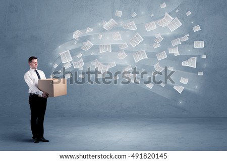 Office documents, contracts, papers flying out of cardboard box being held by a young business worker concept.