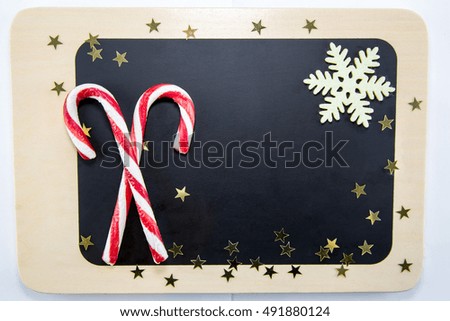 on a blackboard are two candy canes and stars