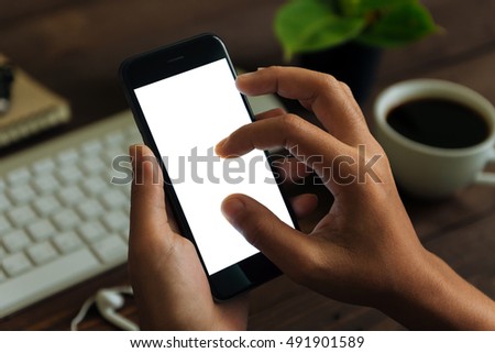 closeup hand use phone showing white screen on work desk, blank phone screen with clipping path easy for adjust app screen