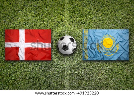 Denmark vs. Kazakhstan flags on green soccer field