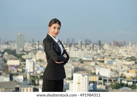 Business woman stand on helipad on top of a skyscraper  in Thailand. 