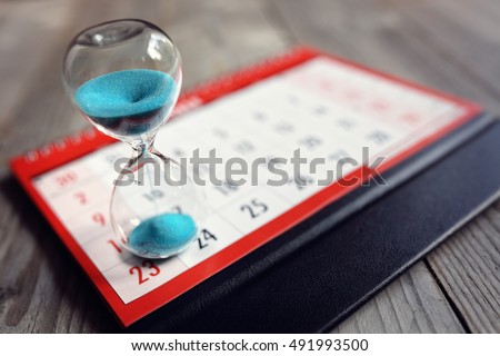 Hour glass on calendar concept for time slipping away for important appointment date, schedule and deadline Royalty-Free Stock Photo #491993500