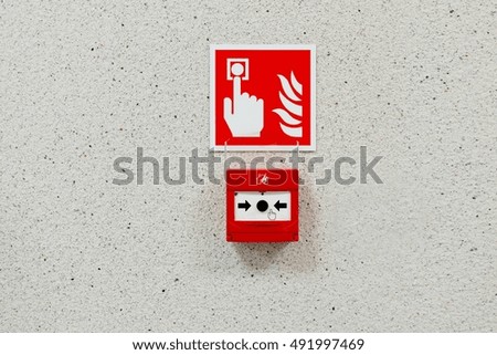 Red fire alarm button installed on the wall