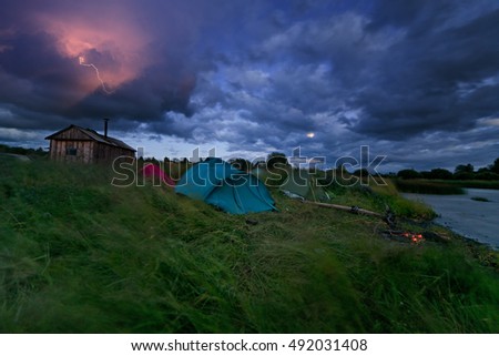 Tents crushed by  heavy wind during severe thunderstorm panorama.