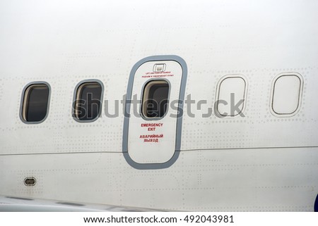Windows of airplane with emergency exit door.