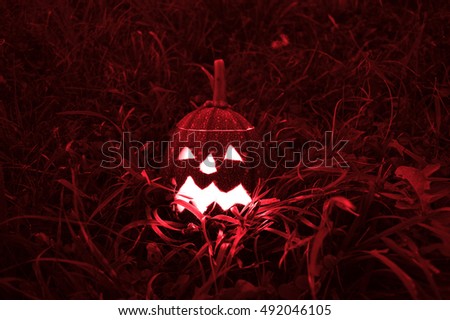Scary Halloween pumpkin isolated on a black background. Red colored scary glowing faces trick