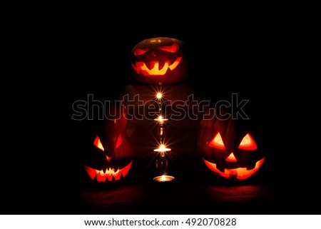 halloween three pumpkins, one on the altar and two as servants at the altar with candles in the dark
