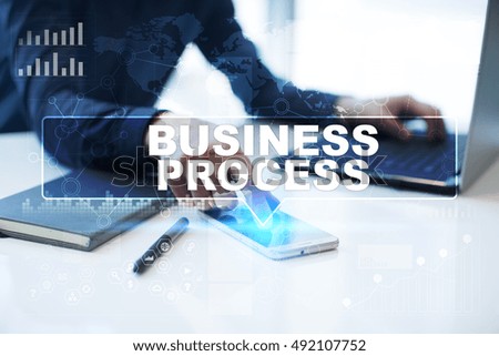 Businessman is working in office, pressing button on virtual screen and selecting "Business process". Business concept.