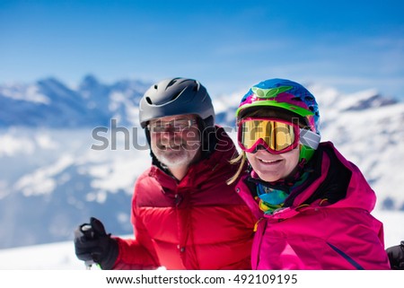 Happy mature couple skiing in the Alps mountains. Senior man and woman enjoying ski vacation in alpine resort. Active retirement. Healthy winter sport for every age.