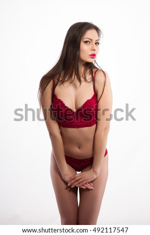 Girl in red underwear on white background. Studio portrait.