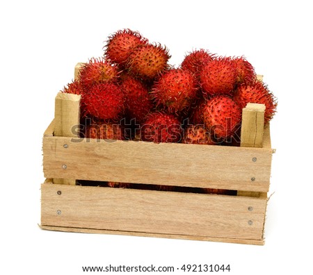 ripe Rambutan fruits in a wooden box isolated on white background