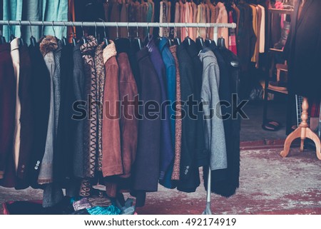 Selective focus some used leather clothes hanging on a rack in market. retro picture style