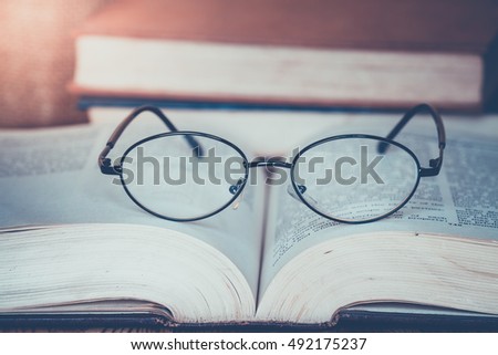 Old glasses on vintage book ,retro picture style