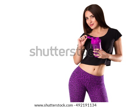 Sports young woman with a shaker in hand. Cool girl in fashion training tights. Tanned athletic girl in purple pants.  Copy space. isolated on white background