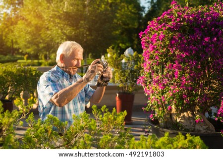 Senior man with camera. Elderly male outdoor. Grandpa found a new hobby. Impressive photos of nature. Few more pictures.