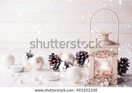 Christmas lantern with decorations over white shabby wooden background