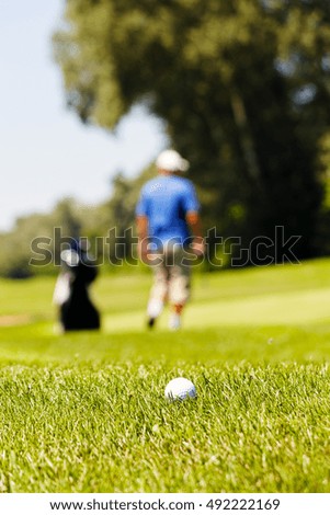 golf course with players, note shallow depth of field